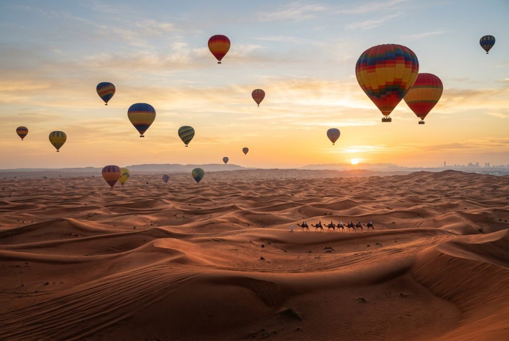 Hot air balloons floating over the Dubai desert at sunrise
